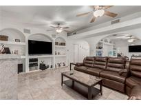 Bright living room with a large leather couch, tile floors, and recessed shelving at 1924 S 6Th St, Las Vegas, NV 89104