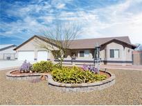 Charming single-story home boasts desert landscaping and a two-car garage under a bright blue sky at 340 Domingo St, Pahrump, NV 89048