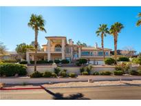 Stunning two-story home featuring a balcony and meticulously landscaped front yard with mature palm trees at 380 Claremont St, Boulder City, NV 89005