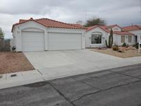 Charming single-story home with a red tile roof, three-car garage and desert landscaping at 4032 Bola Dr, North Las Vegas, NV 89032