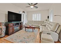 Comfortable living room featuring a neutral color palette, large screen TV, and modern ceiling fan at 4615 Puglia Ln # 201, North Las Vegas, NV 89084
