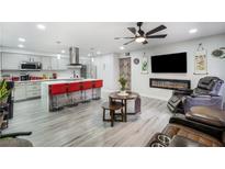 Open-concept living space featuring an island with seating, modern fireplace, and sleek, neutral decor at 5097 Indian River Dr # 172, Las Vegas, NV 89103