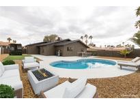 A resort-style backyard featuring a pool, fire pit, and lounge area at 5832 Arandas Ct, Las Vegas, NV 89103