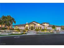 Stunning single-story home featuring manicured landscaping, elegant stone accents, and warm exterior lighting at 6 Ayden Dr, Henderson, NV 89052