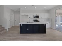 Modern kitchen featuring white cabinets, subway tile backsplash, and a large island with a black base at 793 Vortex Ave, Henderson, NV 89002