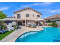 Inviting backyard features a large pool, spa, patio with seating, and a well-maintained lawn for outdoor enjoyment at 8100 Artistic Heights Ct, Las Vegas, NV 89143