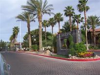 Community entrance featuring lush landscaping, mature palms, and a stately monument sign at Sedona on the Boulevard at 9000 Las Vegas Blvd # 2220, Las Vegas, NV 89123