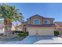 Charming two-story home with a well-manicured front yard and a two-car garage showcasing a red tile roof at 9909 Barrier Reef Dr, Las Vegas, NV 89117