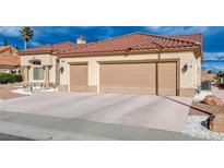 Beige home with a red tile roof and a three car garage with a concrete driveway at 3012 Anna Bay Dr, Las Vegas, NV 89134