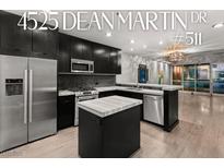 Modern kitchen featuring stainless steel appliances, a center island, and sleek black cabinetry at 4525 Dean Martin Dr # 511, Las Vegas, NV 89103