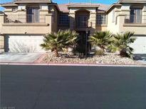 Spacious townhome featuring a two-car garage and desert landscaping at 9301 Harrow Rock St, Las Vegas, NV 89143