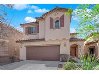 Two-story home with a two car garage and neutral colored facade and tasteful shutters at 10457 Raining Sky St, Las Vegas, NV 89178