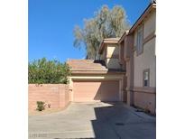 Beige two-story home featuring an attached two-car garage, offering convenient parking and storage at 1463 Evening Song Ave, Henderson, NV 89012