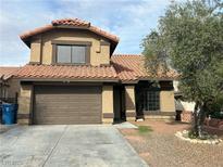 Two-story home featuring a red tile roof and a two-car garage, complimented by well-kept landscaping in front at 228 Moose Ln, Las Vegas, NV 89145