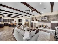 Cozy living room features dark wood beam ceiling, fireplace, and views to kitchen at 296 Brushy Creek Ave, Las Vegas, NV 89148