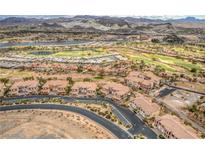 Stunning aerial view of a community with golf course, lake, and mountain backdrop at 64 Strada Principale # 307, Henderson, NV 89011