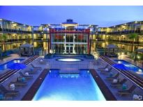 A luxurious pool area with lounge chairs and a spa, surrounded by modern architecture at dusk at 8925 W Flamingo Rd # 310, Las Vegas, NV 89147