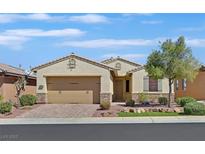 Charming single-story home featuring a manicured front yard, brick driveway, and a two-car garage at 1026 Via Saint Andrea Pl, Henderson, NV 89011