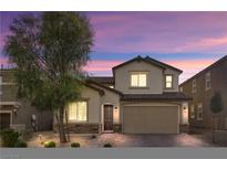 Charming two-story home with a well-manicured front yard and a two-car garage at twilight at 10946 Mount Goyer St, Las Vegas, NV 89141