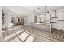 Bright, open-concept living area flows into a modern kitchen with an island and has a sliding door to a patio at 11280 Granite Ridge Dr # 1101, Las Vegas, NV 89135
