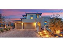 Beautiful two-story home featuring a three-car garage, stone accents, and lush landscaping at 11878 Albissola Ave, Las Vegas, NV 89138