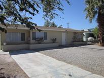 A single-story home with a gravel yard and mature trees in a sunny neighborhood at 2108 E Ogden Ave, Las Vegas, NV 89101