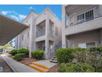 Inviting condo with private balcony, fresh paint and lush landscaping creates a welcoming curb appeal at 2201 Ramsgate Dr # 823, Henderson, NV 89074