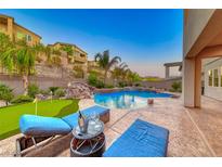 A luxurious backyard oasis featuring a stunning pool, spa, and comfortable lounge seating area at 28 Vista Outlook St, Henderson, NV 89011