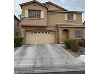 Two-story home featuring tan siding, white shutters, a two-car garage, and well-maintained landscaping at 312 Sierra Breeze Ave, North Las Vegas, NV 89031