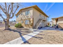 Two-story tan apartment building features a sidewalk and minimal landscaping at 3821 1/2 Daisy St # 26, Las Vegas, NV 89119