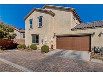 Two-story home boasts a brown two-car garage, stucco exterior, and a brick paver driveway for added curb appeal at 1055 Admiral Emblem St, Henderson, NV 89015