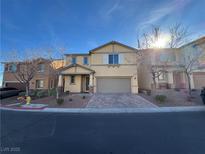 Charming two-story home featuring a well-manicured lawn, a two-car garage and a beautiful blue sky at 10715 York Manor Ave, Las Vegas, NV 89166