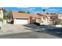 Charming single-Gathering home featuring a tile roof, a two-car garage, and a well-maintained front yard landscape at 3040 Ocean Port Dr, Las Vegas, NV 89117