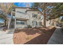 Inviting condo with a well-kept lawn, mature trees, and convenient stairway access to upper units at 3087 Key Largo Dr # 202, Las Vegas, NV 89120