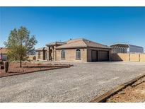 Stunning single-story home with gravel landscaping, an attached garage and an additional metal carport structure at 3780 Shawnee Ave, Pahrump, NV 89048