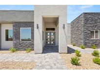 Contemporary home with a modern entrance featuring stone accents, neutral colors, and a walkway at 5719 Christian Creek Ct, Las Vegas, NV 89149