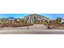 Beautiful two-story home with large windows, arched doorway, desert landscaping and gated entrance at 7025 N Eula St, Las Vegas, NV 89149