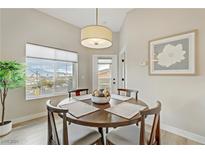 Charming dining area featuring a round wood table, seating for four, and a view of the mountains at 9303 Gilcrease Ave # 2233, Las Vegas, NV 89149