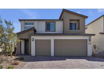 Two-story home with a modern design, neutral color palette, two-car garage, and low maintenance rock landscaping at 10122 Mystic Falls Dr, Las Vegas, NV 89141