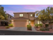 Charming two-story home featuring a terra-cotta roof, attached garage, and low maintenance desert landscaping at 11344 Espadrille Ct, Las Vegas, NV 89138