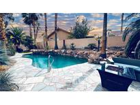 Inviting backyard pool and spa surrounded by desert landscaping and a cozy outdoor seating area at 124 Beach Oak Ave, Henderson, NV 89002