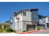 Modern two-story townhome with blue and white exterior, featuring an attached garage and manicured landscaping at 2685 Conifer Canyon St, Henderson, NV 89044