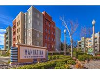 Manhattan Condominiums exterior view featuring a building sign and landscaped greenery at 56 E Serene Ave # 306, Las Vegas, NV 89123