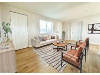 Bright living room with neutral tones, modern furniture, and wood-style flooring at 604 N Minnesota St, Las Vegas, NV 89107