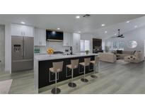 Modern kitchen with stainless steel appliances, a large island with seating, and an open floor plan at 7413 Turtle Dove Ct, Las Vegas, NV 89129