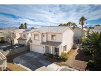 Two-story home boasts a tiled roof, two-car garage, manicured landscaping, and mature palms under a partly cloudy sky at 7820 Esteem St, Las Vegas, NV 89131