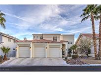 Stunning stucco home featuring a three-car garage, desert landscaping, and a red tile roof at 8032 Marbella Cir, Las Vegas, NV 89128