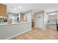 Bright kitchen featuring an open layout, light wood cabinets, and a breakfast bar with decorative accents at 9053 Pearl Cotton Ave, Las Vegas, NV 89149