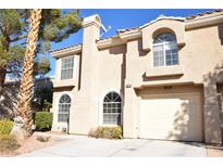 Inviting two-story home with arched windows and a manicured front yard at 9672 Gunsmith Dr, Las Vegas, NV 89123