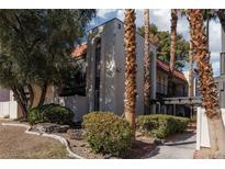Charming townhouse featuring lush landscaping, mature palm trees, and a red tile roof at 1390 Vegas Valley Dr # 25, Las Vegas, NV 89169